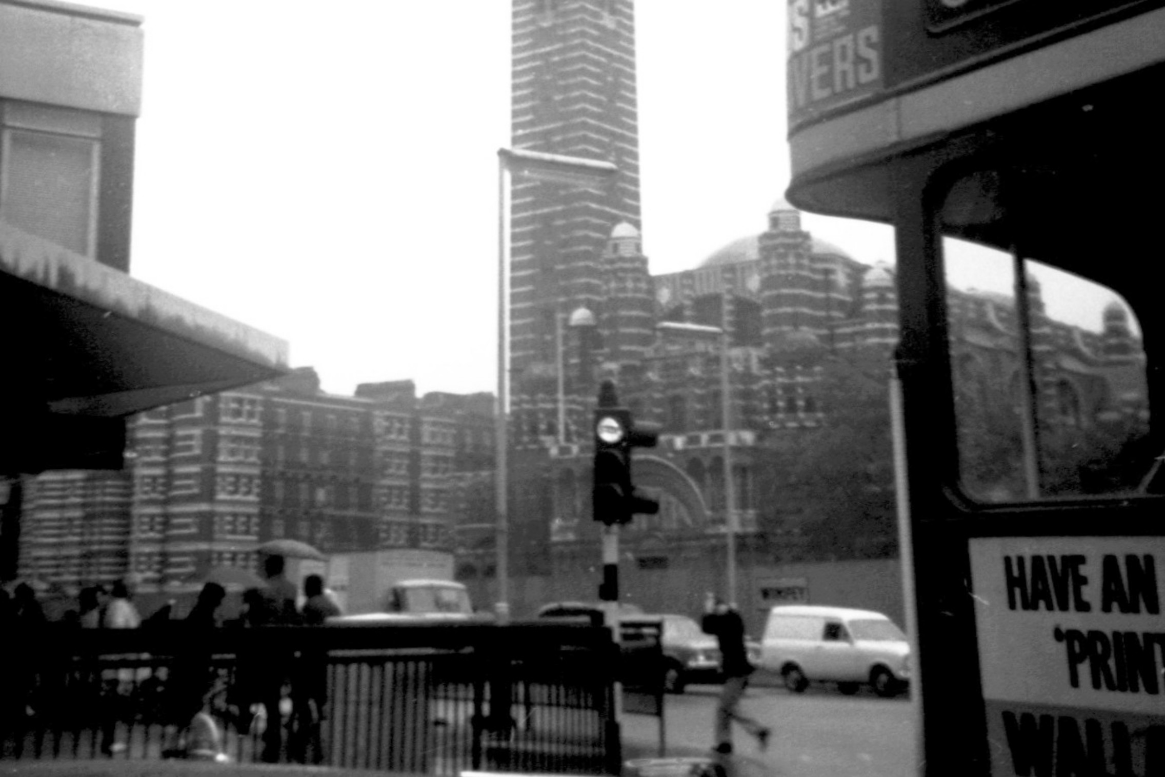 1971年的 Westminster Cathedral 街景，前方可見巴士、行人、交通燈和欄杆。