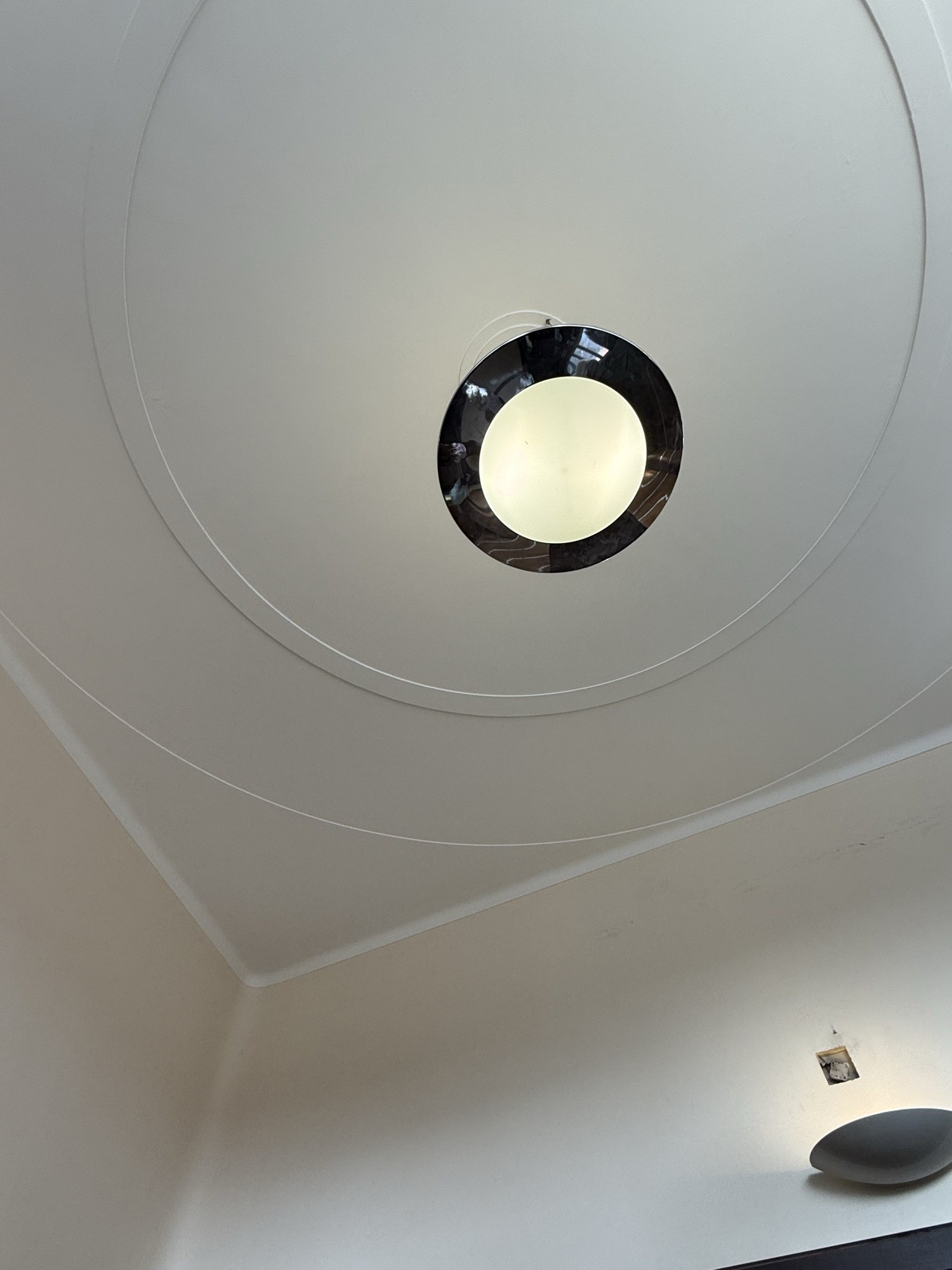入口大堂的圓燈上方，同心圓線腳沿天花展開，幾何造型令人聯想到 Art Deco。