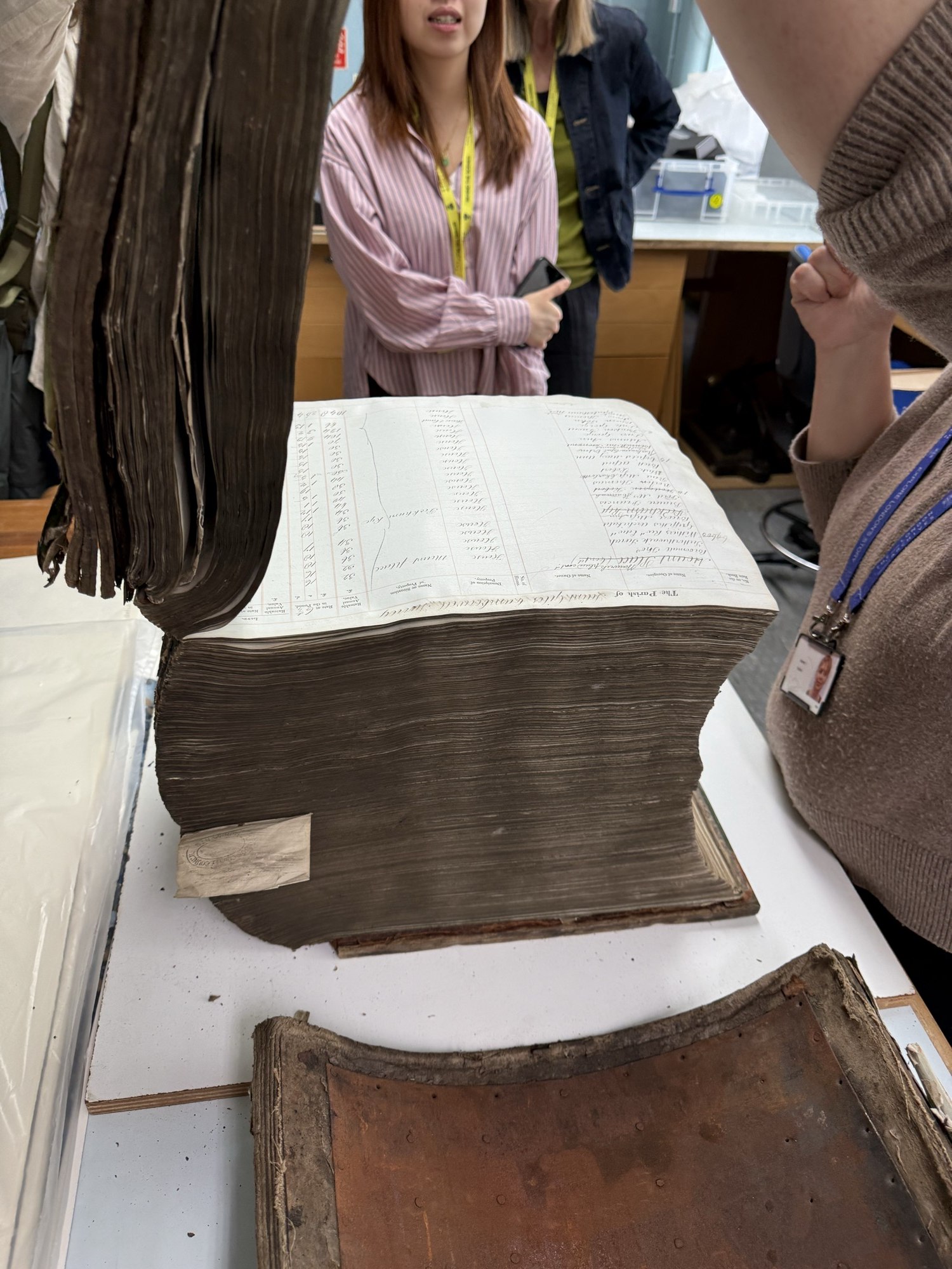 導賞介紹的下水道徵費帳冊：攤開的一頁列出 Saint Mary Newington 教區名稱與分欄金額，厚重書芯旁放着已脫落的封面。