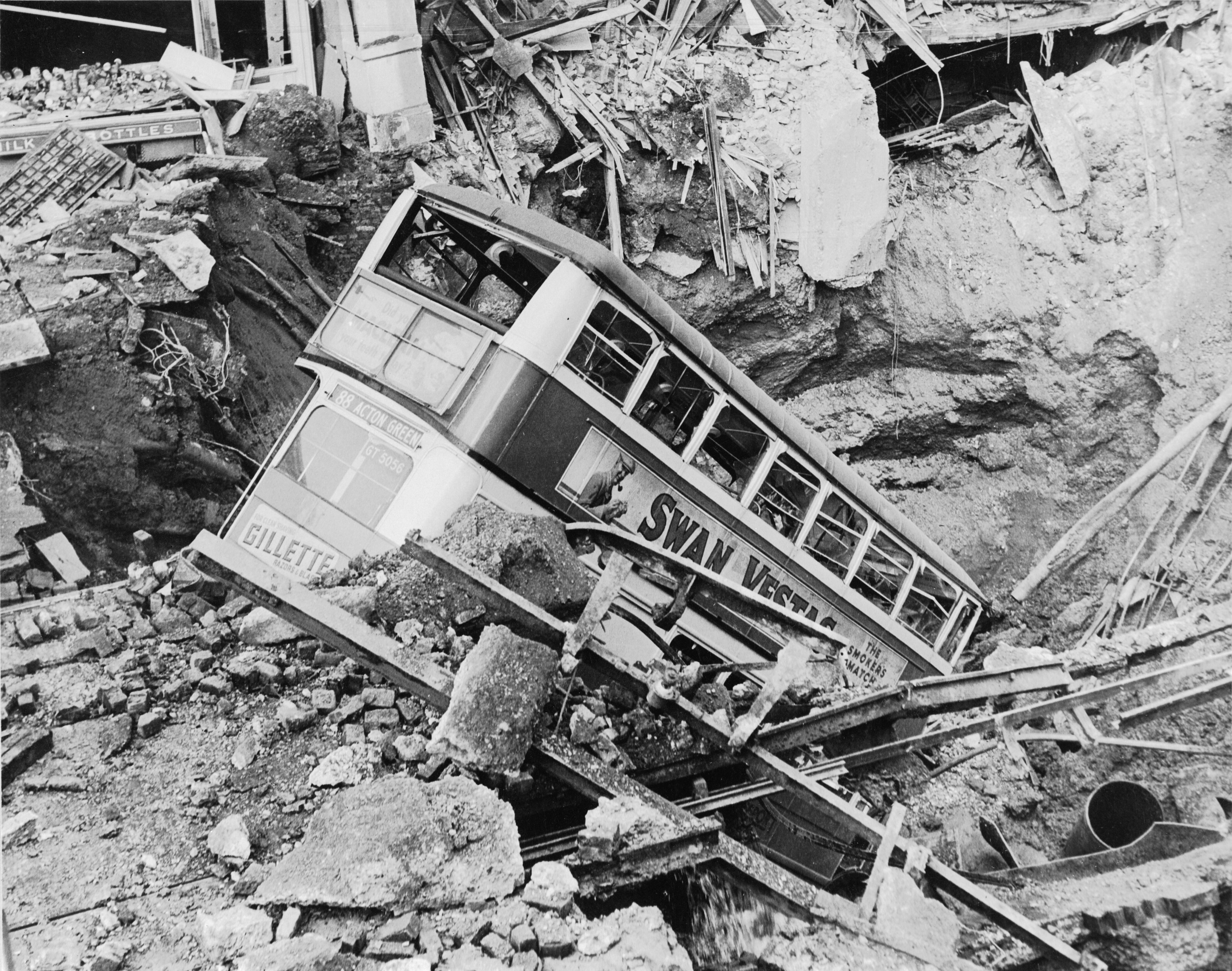 1940 年 10 月，Balham High Road 遭空襲後，一輛巴士陷在彈坑內。10 月 14 日晚的爆炸亦波及下方的地鐵隧道；這張照片的確切拍攝日期未明。