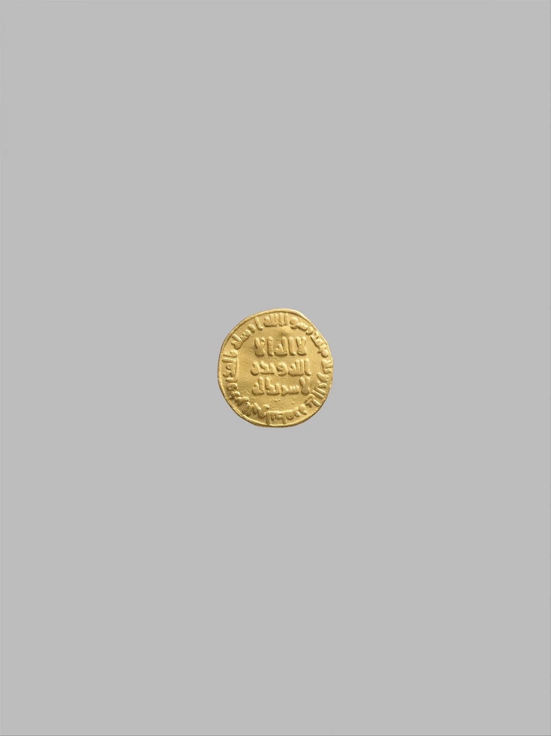 敘利亞鑄造的金第納爾，紀年伊斯蘭曆79年（公元698至699年）。古菲體文字構成幣面；大都會藝術博物館藏，編號99.35.2386。資料圖片。