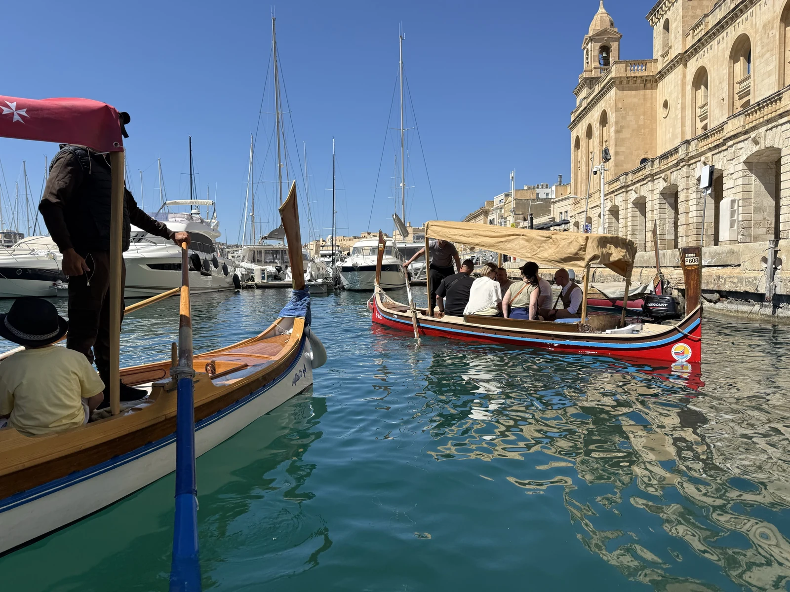 比爾古岸邊的傳統渡船 dgħajsa：尖翹船頭、彩色船身與載客的遮陽棚。